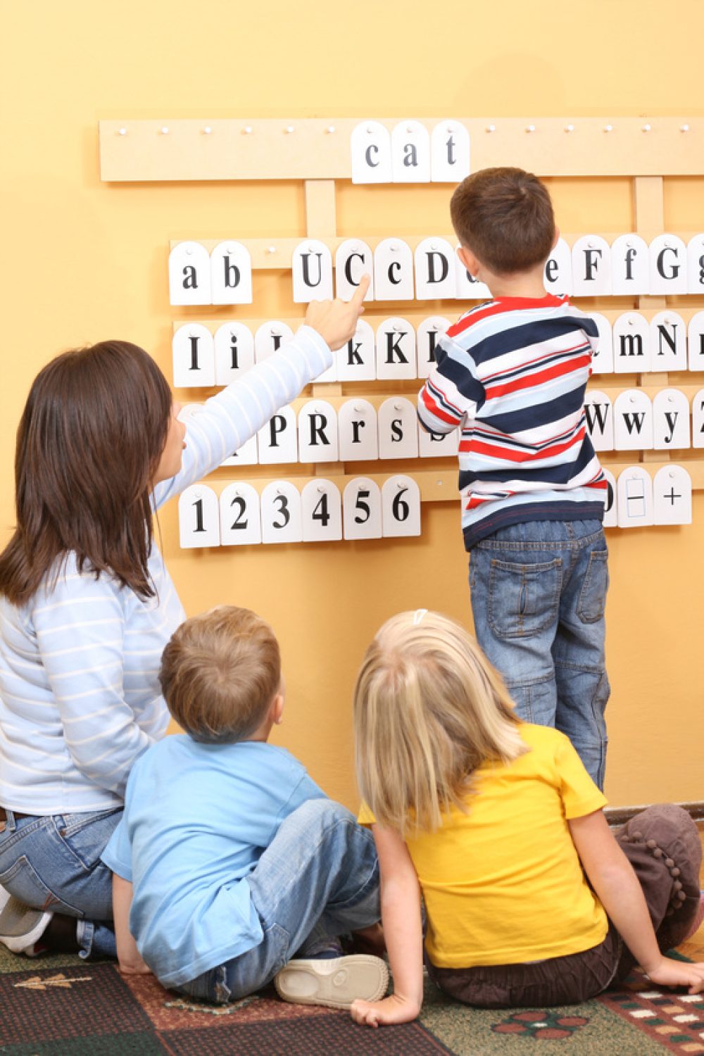 teacher and three preschoolers during lesson